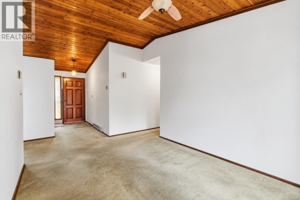 Hallway and entryway with beige carpet, white walls, a vaulted wood plank ceiling, and a ceiling fan. - 946 Paconla Pl, Central Saanich