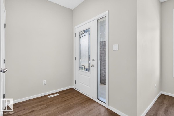 Interior entrance foyer with a glass-paned door, grey walls, and wood-look flooring. - 9478 Colak Ln Sw Sw, Edmonton