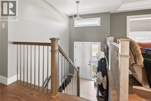 Open-concept living area with kitchen island, dining area, and large windows. - 95 Doiron Street, Dieppe