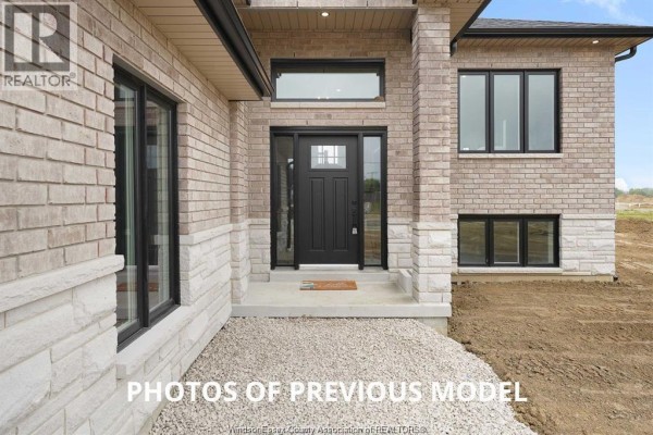Interior view of the foyer showing the front door, staircase with wood railing, and tile flooring. - 95 Fenceline Drive, Chatham