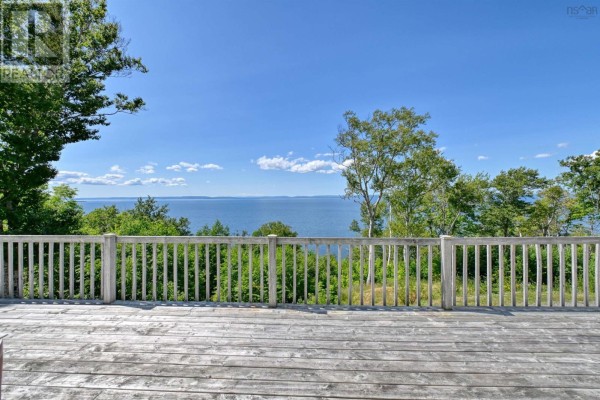 Wooden deck with a railing offers a wide view of the water and distant tree line. - 95 Lakeshore Drive W, Irish Cove