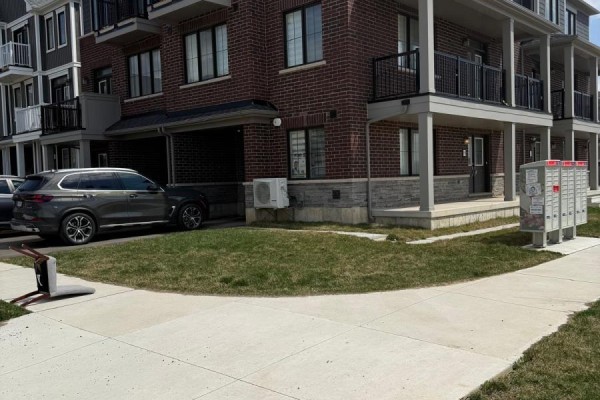 Townhouse exterior with attached garages, balconies, and mailboxes. - 95 Norwich Crescent, Haldimand
