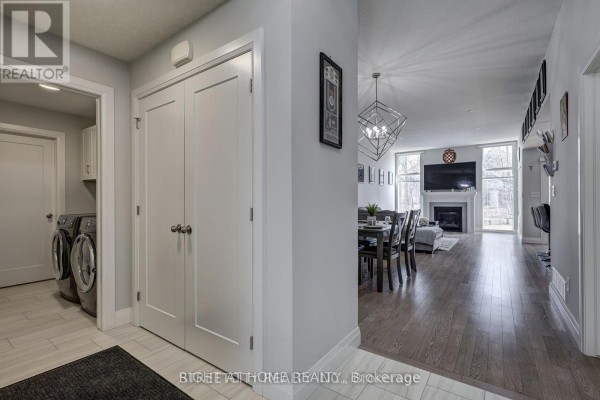 Interior entryway with light grey walls, white door, black mirror, and two rugs. - 95 Optimist Drive, Southwold