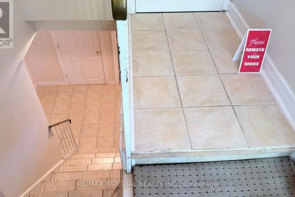 Tiled entrance foyer with a staircase leading down and a "Please Remove Your Shoes" sign. - 95 Pleasant View Drive, Toronto