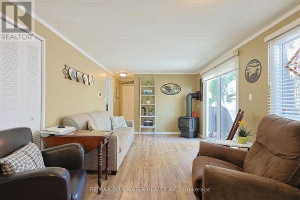 Living room with wood stove, sofa, armchairs, and sliding door - 95 Shannon Boulevard South Huron