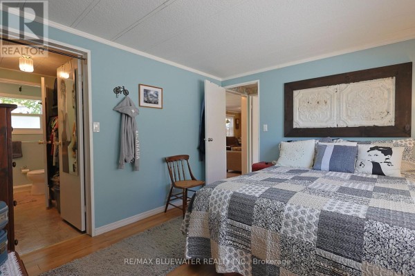 Bedroom with queen bed, patchwork quilt, and ensuite bathroom access - 95 Shannon Boulevard South Huron