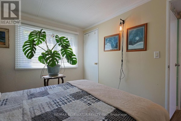 Bedroom with large plant and quilted bed - 95 Shannon Boulevard South Huron