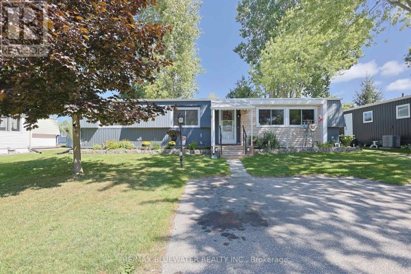 Single-story house with blue/grey siding, stone accents, and a front porch - 95 Shannon Boulevard South Huron