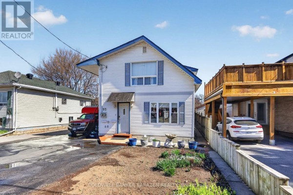 Front exterior of a white two-story house with blue shutters and a wooden deck. - 95 Ste Cecile Street, Ottawa