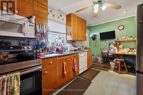 Kitchen with light wood cabinets, stainless steel stove, and green walls. - 95 Ste Cecile Street, Ottawa