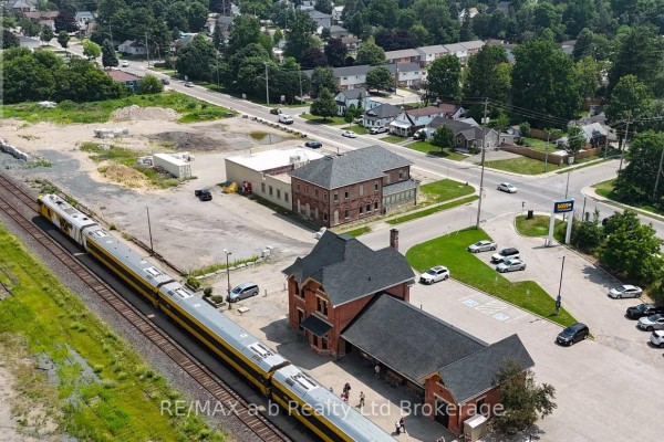 Aerial view of a brick commercial building with large windows and adjacent parking lot. - 95 Victoria Street S, Woodstock