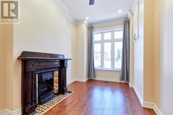 Bedroom with a queen-size bed, blue floral bedding, and dark hardwood floors. - 95 Wolseley Street, Toronto