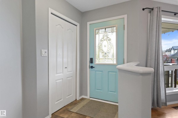 Interior entryway with a blue door, closet, and light grey walls. - 9506 83 Av, Morinville