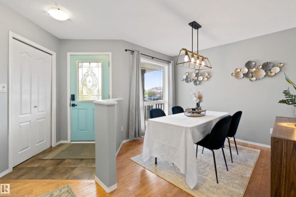 Dining area with a table set for four and a view of the entryway. - 9506 83 Av, Morinville