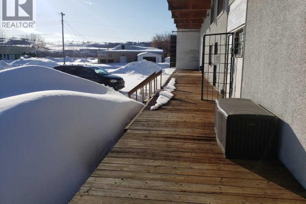 Wooden ramp leading to commercial building entrance with deep snowdrifts. - 9510 90 Avenue, Peace River