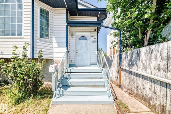 Close-up of the front entrance with light blue stairs, white door, and mailbox. - 9518 106 Av Nw, Edmonton