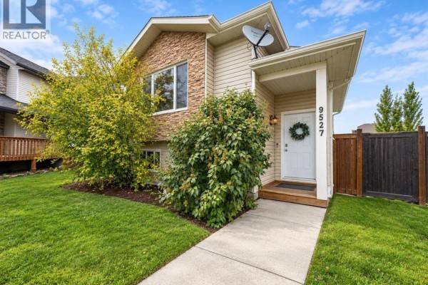 Front entrance of a beige house with address number 9527 and a wreath on the door. - 9527 93 Street, Wembley