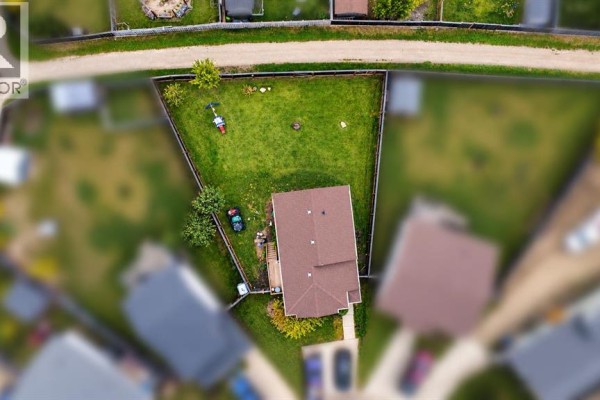 Aerial view of a house with a fenced backyard and lawn, surrounded by other properties. - 9527 93 Street, Wembley