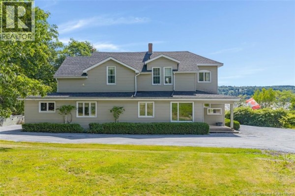 Side view of the house showing beige siding, multiple windows, and a manicured hedge row. - 9531 Route 102, Morrisdale