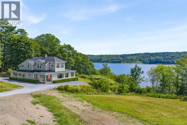 Aerial view of the house and its surrounding green landscape overlooking a wide, tree-lined lake. - 9531 Route 102, Morrisdale