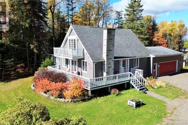 Aerial view of the grey house with a garage and surrounding lawn and trees. - 954 Main Street, Grand Sault/grand Falls