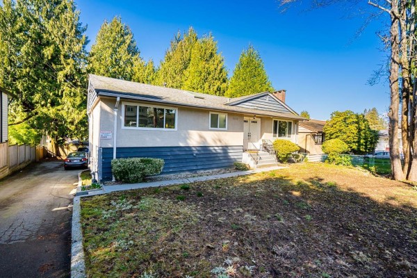 Side view of the house showing the entrance and surrounding greenery - 9545 116 Street, Delta