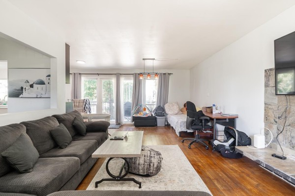 Living room with a large sectional sofa, desk area, and natural light from windows - 9545 116 Street, Delta