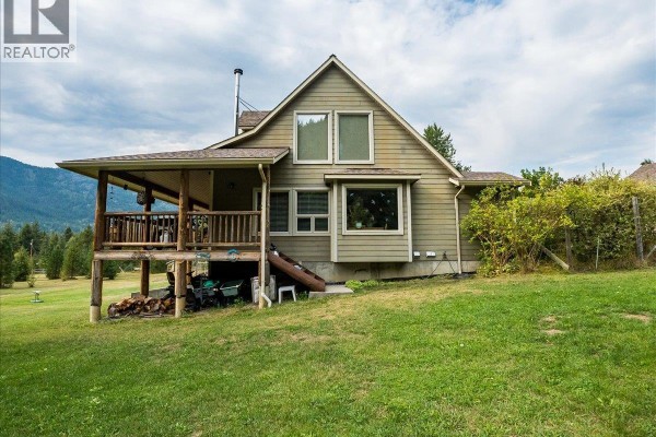 Bedroom with sloped ceiling, wood paneling, hardwood floors, and mountain view through two windows. - 955 Cedar Brae Road, Glade
