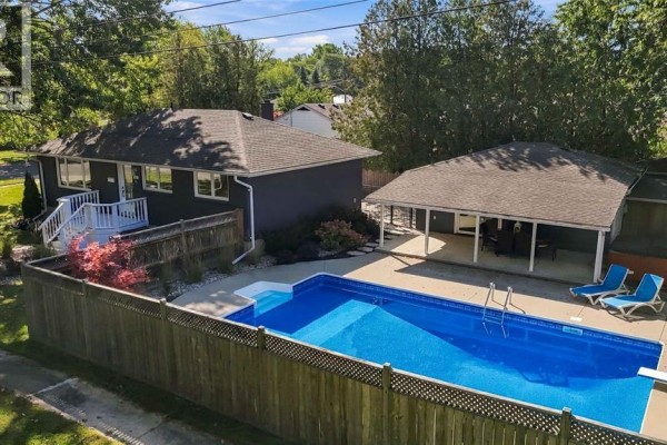 Aerial view of a bungalow with a backyard swimming pool and covered patio. - 957 Kensington Boulevard, Sarnia