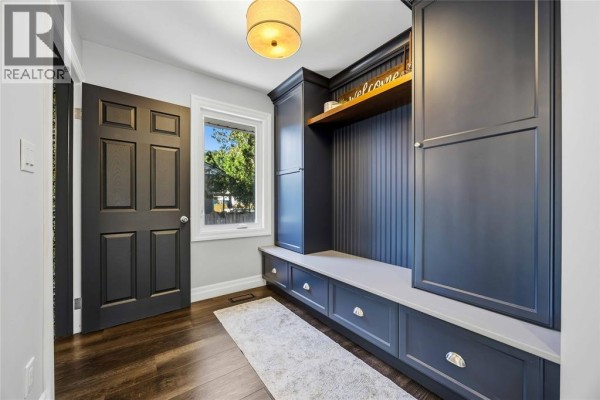 Mudroom with dark grey built-in cabinetry, bench seating, and a dark grey door. - 957 Kensington Boulevard, Sarnia