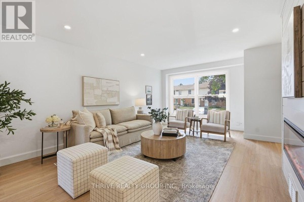 Living room with a large window offering a view of the street, a neutral sofa, and chairs. - 96 - 51 Sholto Drive, London South