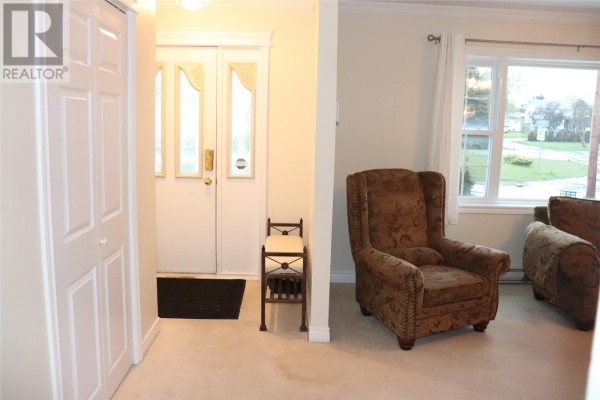 Hallway entrance with double front doors, closet, and a view of a living room armchair. - 96 Colonial Avenue, Stephenville