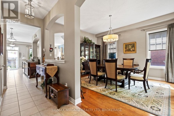 View from hallway into dining room and living area with arched doorways. - 96 Garrison Village Drive, Niagara On The Lake
