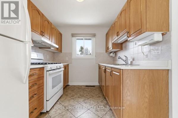 Kitchen with light oak cabinets, white appliances, beige tile backsplash, and checkered tile floor. - 96 Glendale Avenue, Deep River