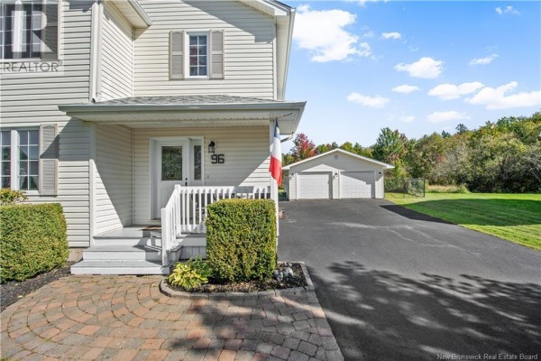Close-up of the front entrance with a white porch, stairs, and decorative bushes. - 96 Nicolas Street, Dieppe