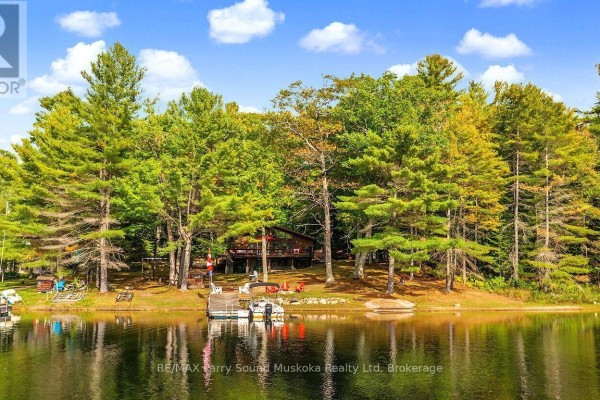 Waterfront property with a cabin, dock, and treed shoreline. - 96 Georgian Bay Wa Zone L, Carling