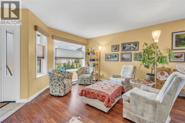 Living room with light yellow walls, wood floors, and four chairs. - 9600 Turner Street Unit# 20, Summerland