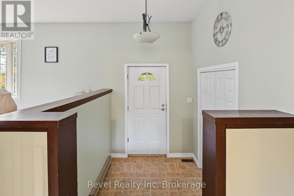 Interior view of a home foyer with a white front door, light green walls, and dark brown trim. - 9614 Hwy 63, Unorganized Townships