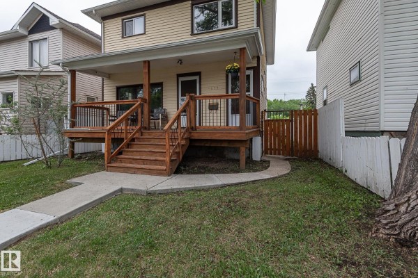 Close-up view of the wooden porch and steps of a yellow house. - 9623 110a Av Nw, Edmonton
