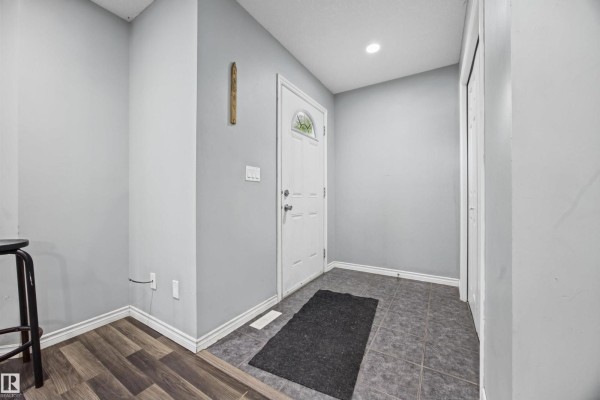 Entryway with grey walls, dark grey floor tiles, and a black doormat. - 9626 106 Av Nw, Edmonton