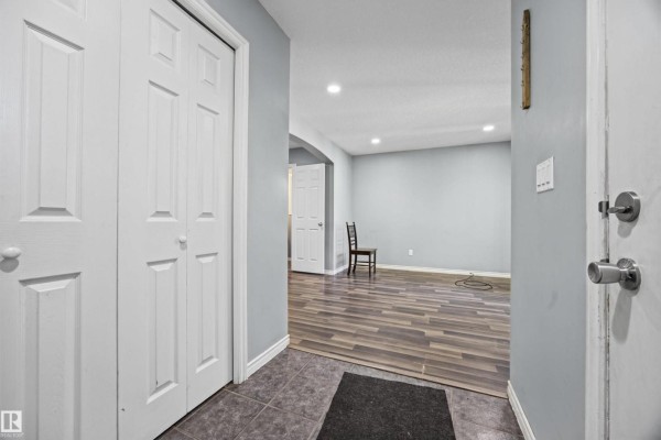 View from entryway showing double white doors on the left and an open doorway to a living area. - 9626 106 Av Nw, Edmonton