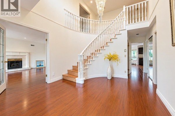 Living room with a cream fireplace, bay windows, and dark hardwood floors. - 963 Merritt Street, Coquitlam