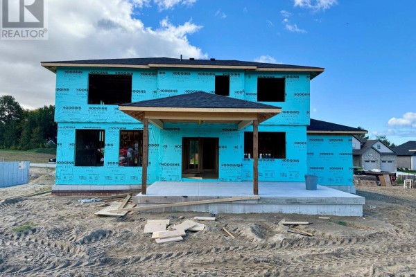 Rear view of a house under construction showing blue wrap, covered patio, and concrete foundation. - 968 Bogdanovic Way, Huron Kinloss