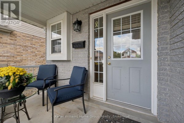 Front door and porch area with two blue chairs and a glass table. - 97 Teal Drive, Guelph