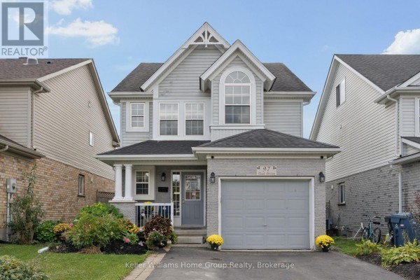 Front exterior of a two-story grey house with a grey garage door and a porch with white columns. - 97 Teal Drive, Guelph