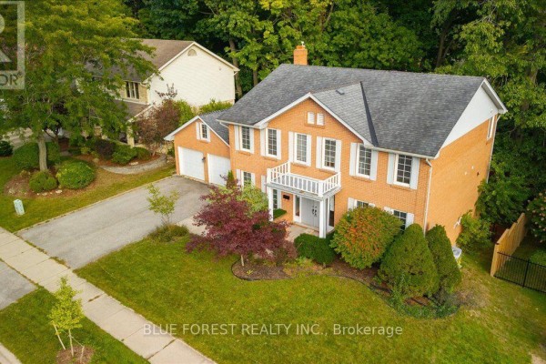 Aerial view of a two-story brick house with a double garage, pitched roof, and lush landscaping. - 97 Timber Drive, London South