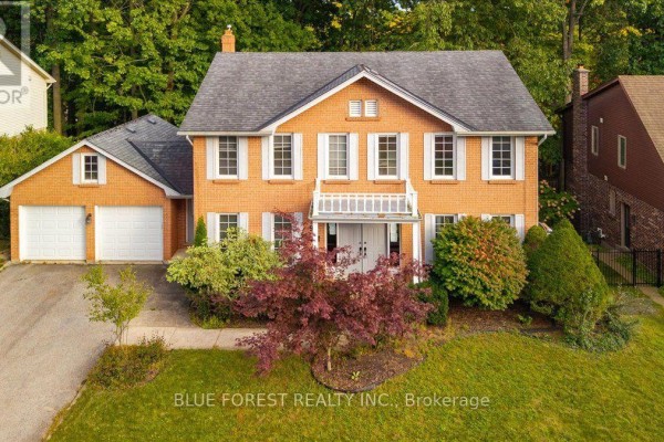 Eye-level view of a two-story brick house with a double garage, white shutters, and a covered balcony. - 97 Timber Drive, London South