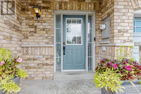 Front door of a townhouse with glass panels, sidelights, and brick surround. - 97 Timbertop Crescent, Brampton