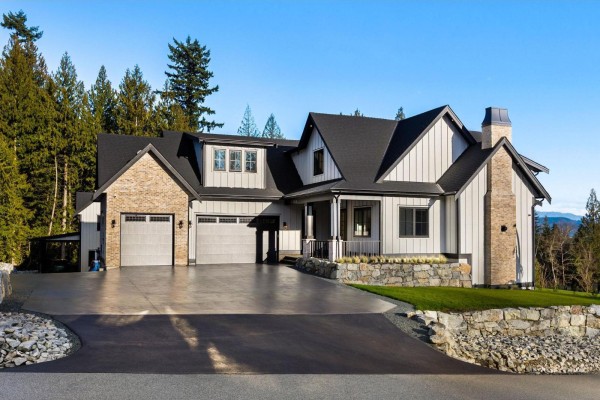 Open concept living and kitchen area with light wood floors, vaulted ceiling, and large windows. - 9700 Gough Terrace, Mission