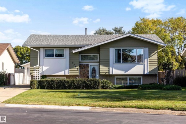 Front exterior of a single-family home with a sloped roof, light green siding, and a concrete driveway. - 9703 104 St, Morinville